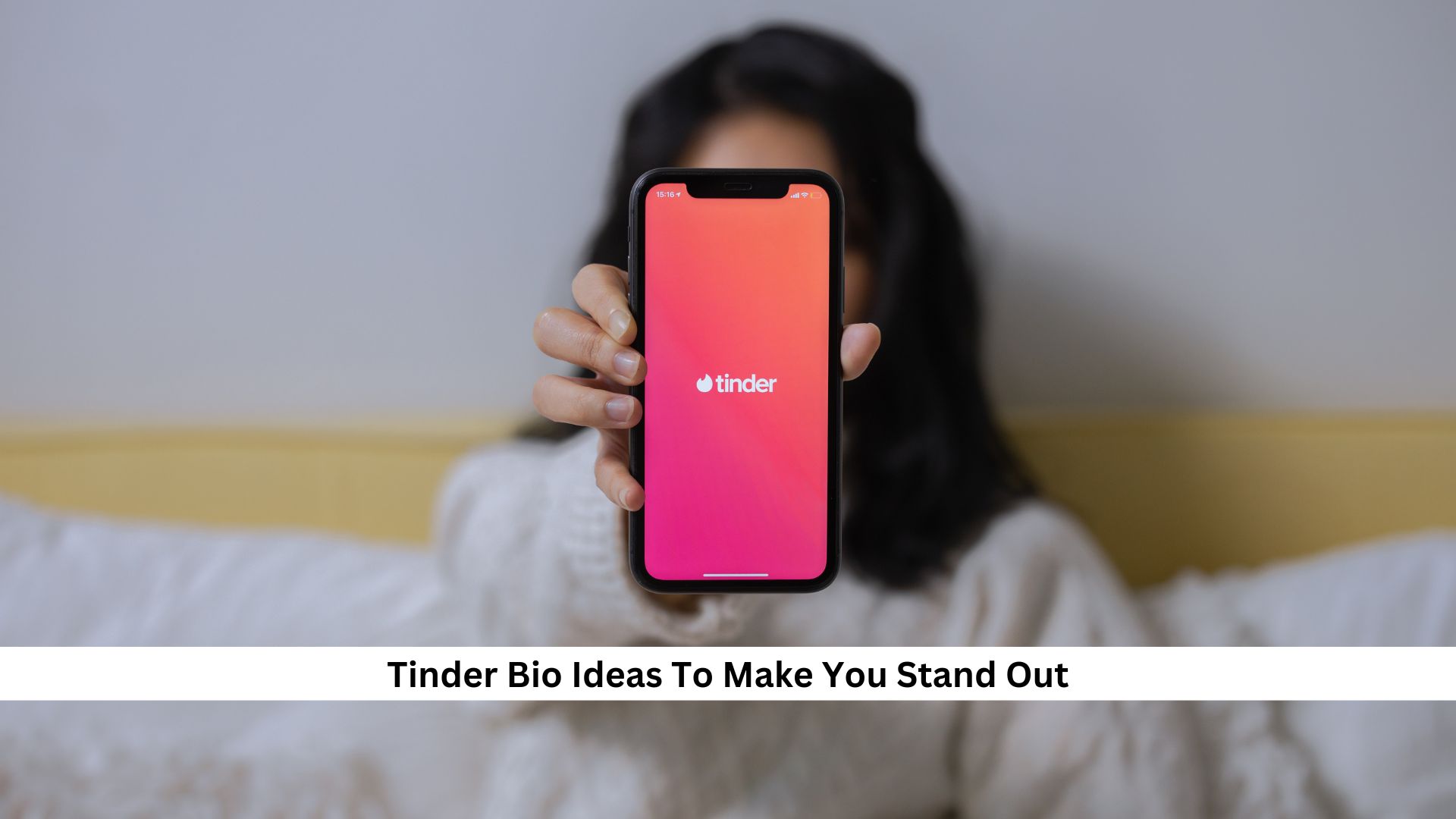 Person holding phone with Tinder app open, suggesting standout bio ideas.